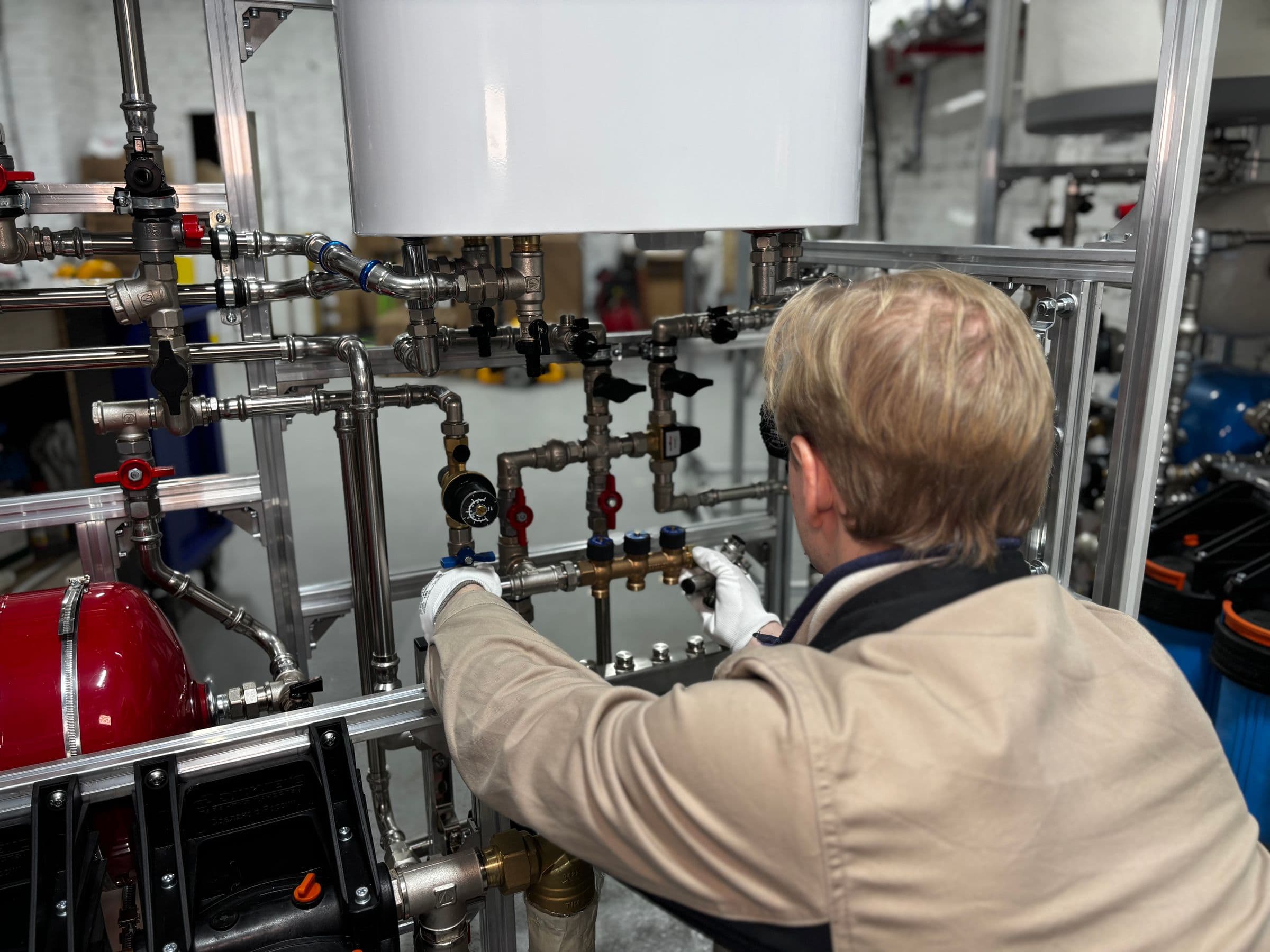 A technician adjusting valves on a mechanical piping system